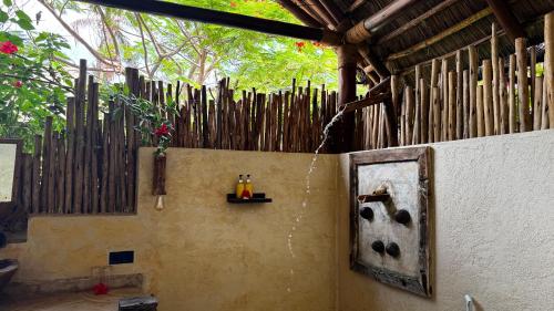 a wall with a wooden fence and a shelf on it at The Nest Tropical Oasis Resort in Paje