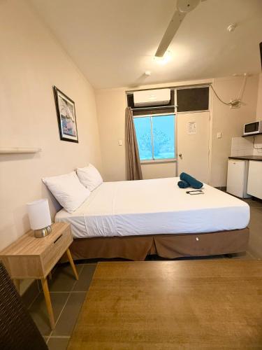 Un dormitorio con una cama grande y una mesa. en Tropical River Hotel, en Katherine