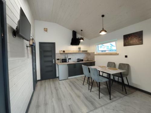 a kitchen and dining room with a table and chairs at Family House Volosianka in Volosyanka
