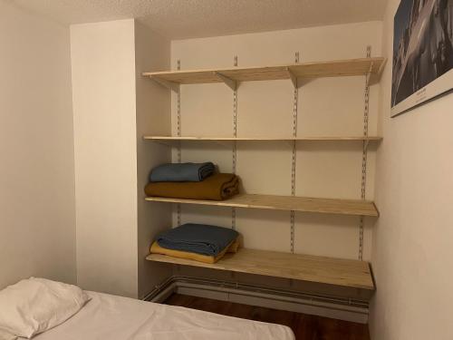 - une chambre avec des étagères en bois et un lit dans l'établissement Apartement PRAZ SUR ARLY, à Praz-sur-Arly
