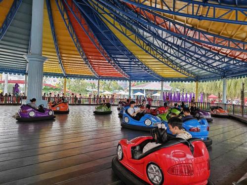 a group of children riding in toy cars in an amusement park at Dinosaurs House - New apartment, Vinhome Grand Park-2BR,2WC, 5 guests in Gò Công