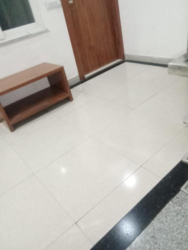 a white tiled floor with a bench and a door at Triple One Hotel Tapovan Rishikesh,Near Laxman Jhula in Rishīkesh