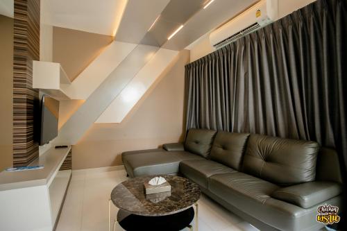 a living room with a couch and a table at Boat House Boutique Riverside in Talat Amphoe Nakhon Chai Si