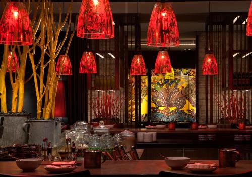 a restaurant with red chandeliers and a table with chairs at Rosewood Beijing in Beijing