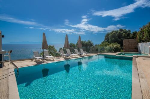 a swimming pool with chairs and umbrellas at Pelagos Blue Zante in Vasilikos