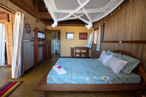 a bedroom with a bed with a blue comforter at Maningory in Ile aux Nattes