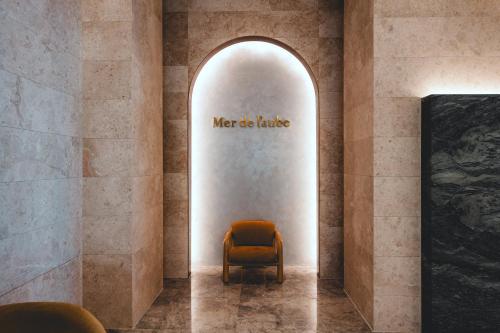 a chair in a room with a sign on the wall at Mer de laube Hotel in Busan