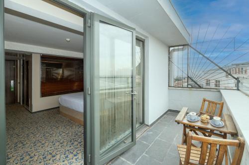 a room with a balcony with a bed and a table at Pera Tulip Hotel & Spa - Istanbul Taksim Pera City Center in Istanbul