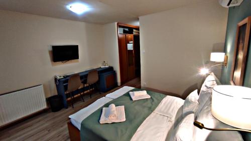 a hospital room with a bed with towels on it at Átrium Hotel Harkány in Harkány