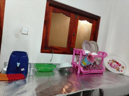a counter top with pink dishes and a mirror at New mom house in Tangalle