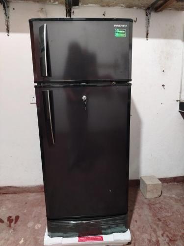a black refrigerator is sitting in a room at New mom house in Tangalle