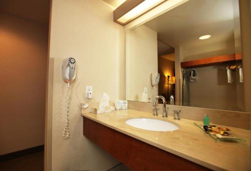a bathroom with a sink and a phone on the wall at St. Albert Inn & Suites in St. Albert