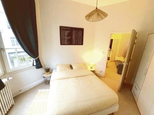 une chambre avec un lit et une fenêtre dans l'établissement Appartement charmant au pied de la Basilique, à Saint-Quentin