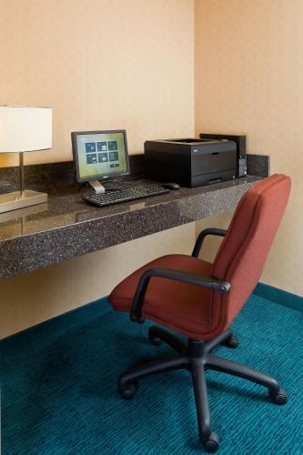 a red chair sitting in front of a desk with a computer at Residence Inn Youngstown Boardman/Poland in Poland