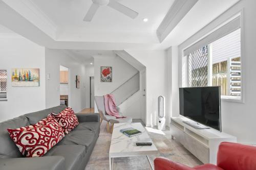 a living room with a couch and a tv at The Villa on Shire - Comfort near Coorparoo Square in Brisbane