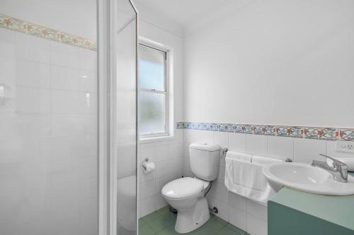 a white bathroom with a toilet and a sink at The Villa on Shire - Comfort near Coorparoo Square in Brisbane