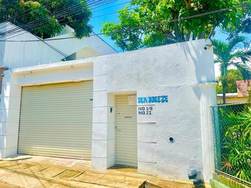 a garage door with a sign on the side of a building at Sea Breeze Guest House Negombo in Negombo