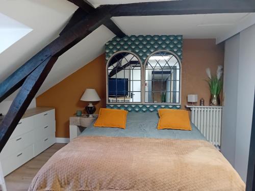 une chambre avec un grand lit avec des oreillers orange dans l'établissement Coeur Historique - CosyHome 18 - Parking à proximité, à Pau