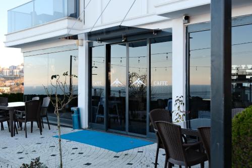 a patio with a table and chairs and a building at Şahin Tepesi Suite Otel in Trabzon