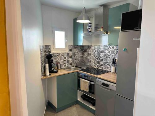 une cuisine avec un évier et une cuisinière four supérieur dans l'établissement Super logement familial, au Grau-du-Roi