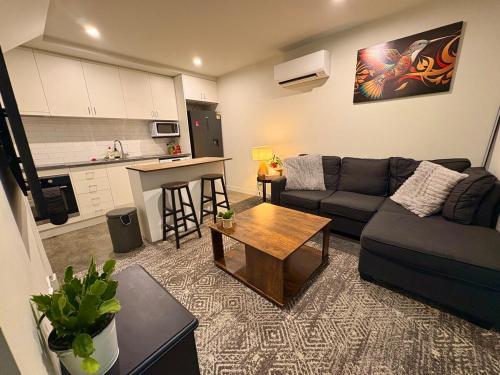 a living room with a couch and a table at Devonport CBD Modern Loft in Devonport