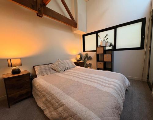 a bedroom with a large bed and two windows at Devonport CBD Modern Loft in Devonport