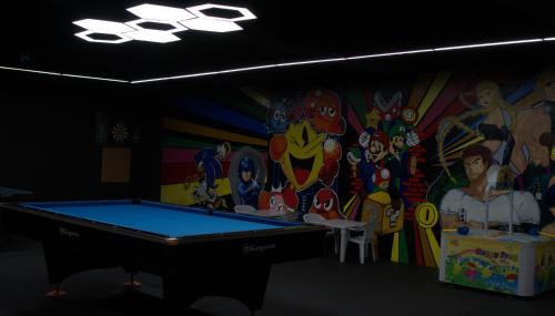 a room with a pool table in front of a mural at Luxent Hotel in Manila