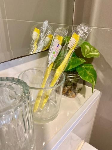 a bunch of toothbrushes in a glass bowl on a shelf at Double J Room the east ville Bangsean in Ban Hua Khao Sammuk