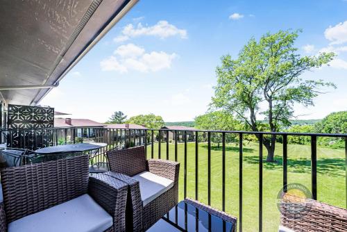 a balcony with chairs and tables and a view of a field at YOUR New Luxury Lakeview Condo w Pool Access in Lake Geneva
