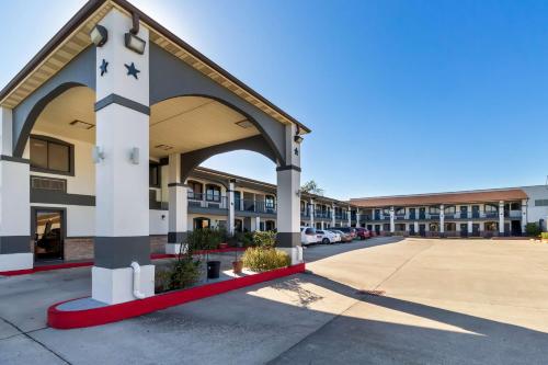 a building with an archway in a parking lot at Americas Best Value Inn Houston Heights at I-45 in Houston