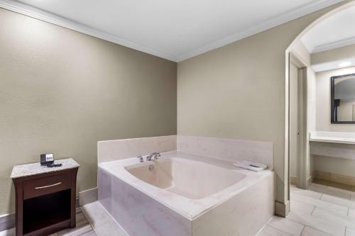 a large white bath tub in a bathroom at Americas Best Value Inn Houston Heights at I-45 in Houston
