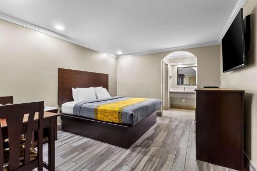 a hotel room with a bed and a television at Americas Best Value Inn Houston Heights at I-45 in Houston