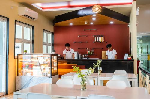 ein Restaurant mit zwei Köchen, die hinter der Theke stehen in der Unterkunft La Piazza Hotel and Convention Center Inc. in Legazpi