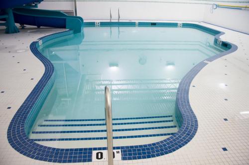 a swimming pool with blue tiles on the floor at St. Albert Inn & Suites in St. Albert