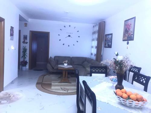 a living room with a couch and a clock on the wall at Villa Rejan in Pogradec