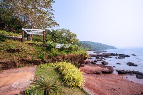 a bench sitting on top of a cliff next to the water at Stone Water Eco Resort in Bogmolo