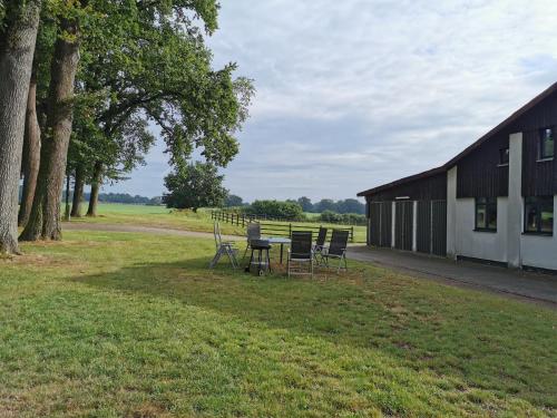 a picnic table and chairs next to a barn at Beekenhof in Bommelsen