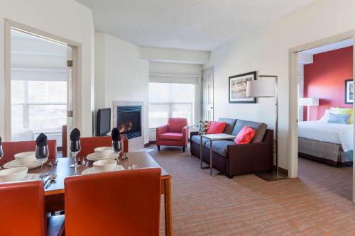 a hotel room with a bed and a living room at Residence Inn by Marriott Bloomington by Mall of America in Bloomington