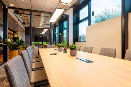 a long wooden table in an office with chairs at Hessnery Hotel in Tallinn