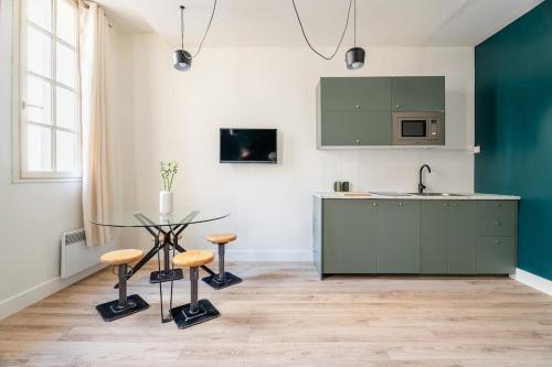 - une cuisine avec une table en verre et un évier dans l'établissement Appartement neuf, plein centre historique, à Marseille