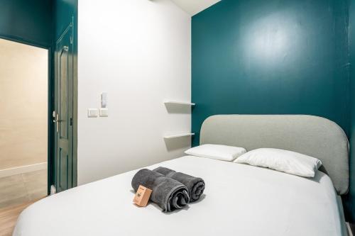 une chambre avec un lit blanc avec un mur bleu dans l'établissement Appartement neuf, plein centre historique, à Marseille