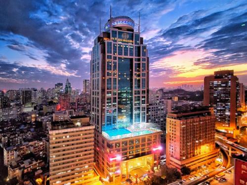 a tall building with lights on in a city at Asia International Hotel Guangdong in Guangzhou