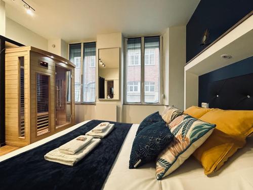 une chambre avec un grand lit avec deux serviettes dessus dans l'établissement Saun arene grand T2 proche gare avec sauna, à Reims