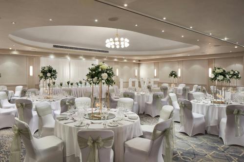 a banquet room with white tables and white chairs at Portsmouth Marriott Hotel in Portsmouth