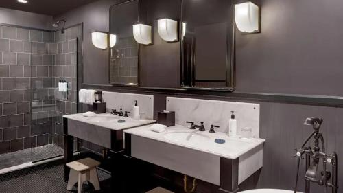 a bathroom with two sinks and two mirrors at The Barnett, part of JdV by Hyatt in New Orleans