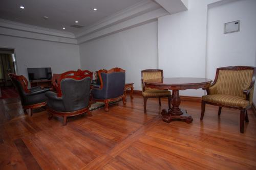 a waiting room with chairs and a table and a television at Weston Hotel in Nairobi