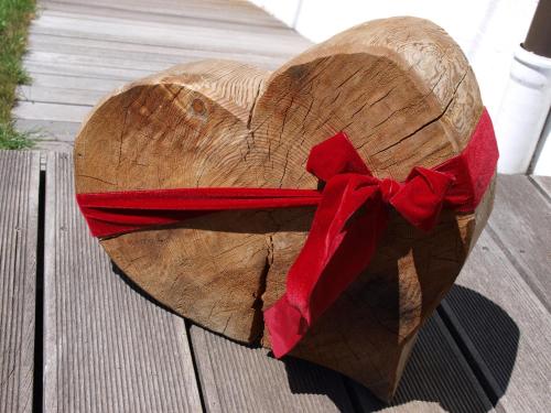 a wooden heart with a red bow on top at Alpenferienwohnung Strickner in Neustift im Stubaital