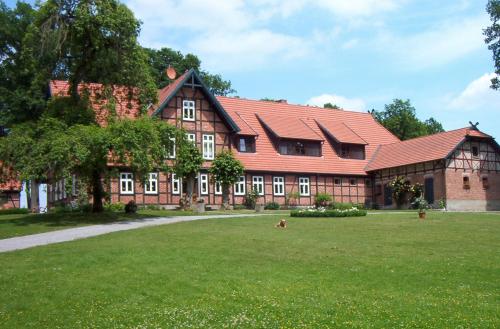 a large red building with a grass field in front of it at Beekenhof in Bommelsen