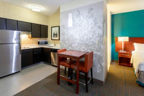 a small kitchen with a table and a bed at Residence Inn Minneapolis St. Paul/Roseville in Roseville