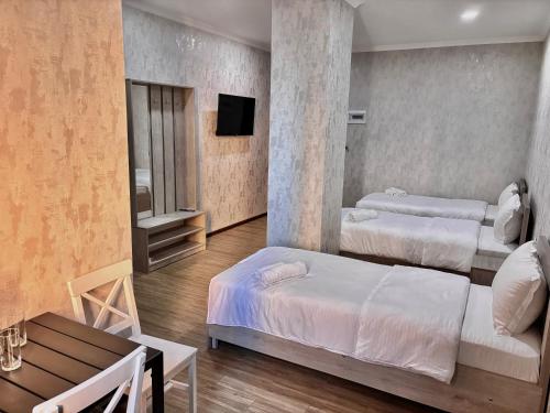 a hotel room with two beds and a tv at Solo Palace in Rustavi